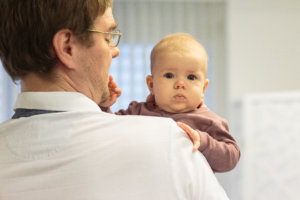 Dr. Urs Kalberer mit einem Baby. Bieler Frauenarzt für Kinderwunsch.